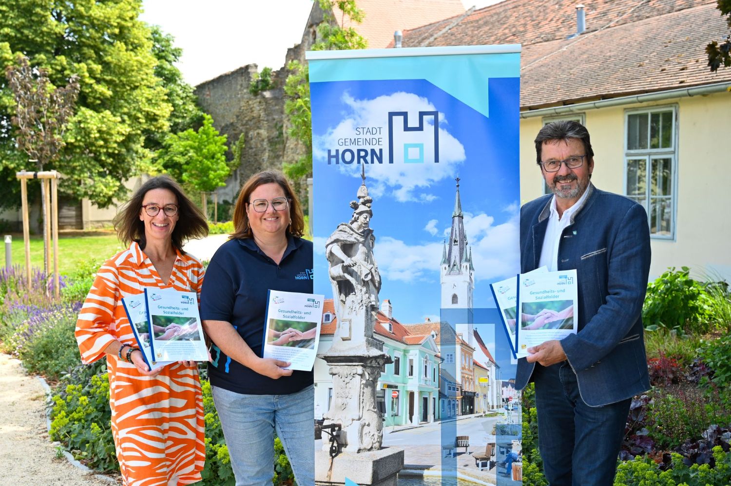 Barbara Stark, Karina Mikysek und Gerhard Lentschig präsentieren Folder